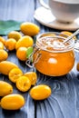 Kumquat on plate and jam in jar at wooden table