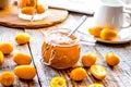 Kumquat on plate and jam in jar at wooden table