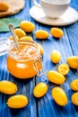 Kumquat on plate and jam in jar at wooden table Royalty Free Stock Photo