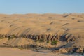 Kunene River in front of towering ancient Namib Desert sand dunes of Namibia and Angola Royalty Free Stock Photo