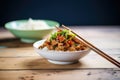 kung pao chicken with chopsticks placing a piece on rice Royalty Free Stock Photo