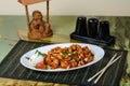 Kung Pao Chicken, a spicy fried Chinese dish made with cubed chicken, peppers, and peanuts. Wooden background. Royalty Free Stock Photo