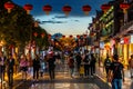 Beautiful street view of Guandu ancient town full of people with Chinese lanterns and main gate in distance at night in Kunming Royalty Free Stock Photo