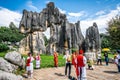Chinese tourists in traditional dress posing in front of the famous stone screen in Shilin stone forest Yunnan China