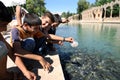 Kurdish boys feed the sacred fish at Balikli Gol (Pool of Sacred Fish) in Urfa (Sanliurfa).