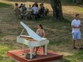 Lady playing white piano, village charity event