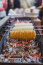 Kurtos kalacs or Chimney Cakes roll spinning over hot coals at a market stand,the typical sweet of Budapest,Hungary Royalty Free Stock Photo