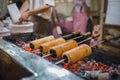 Kurtos kalacs or Chimney Cakes roll spinning over hot coals at a market stand,the typical sweet of Budapest,Hungary Royalty Free Stock Photo