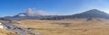 Kusasenri (kusasenri-ga-hama) prairie, fuming Mt. Naka and Mt. Eboshi in the background Royalty Free Stock Photo