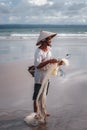 Balinese fisherman with a net and fish catch on the ocean.