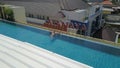 Kuta, Bali, Indonesia, March 13, 2021. Aerial footage of a man in the pool on the roof of luxury hotel Atanaya. A drone