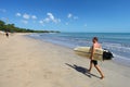 Kuta Beach in Kuta, Bali, Indonesia with a Man Carrying a Surfboard Royalty Free Stock Photo