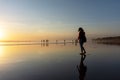 Silhouette of woman strolling and enjoying sunset at Seminyak beach in Bali