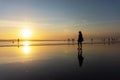 Silhouette of woman strolling and enjoying sunset at Seminyak beach in Bali