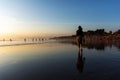 Silhouette of woman strolling and enjoying sunset at Seminyak beach in Bali