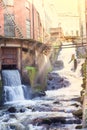 Kvarnbyn Waterfall in old industrial work area in Molndal, Gothenburg, Sweden, sun rays effect