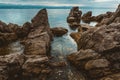 Kvarner gulf of Adriatic sea rocky coastline, large rocks at shoreline in old town of Lovran in Croatia