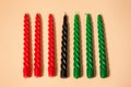 Kwanzaa African American celebration. Seven red, black and green candles on natural beige background. Symbols of African heritage