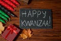 Kwanzaa African American holiday. Seven candles red, black and green on natural wooden background.