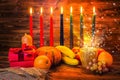 Kwanzaa holiday concept with traditional lit candles, gift box, Royalty Free Stock Photo