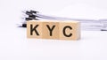 KYC word on wooden cubes. the background is a business papers. finance concept Royalty Free Stock Photo