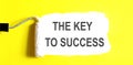 THE KYE TO SUCCESS One open can of paint with white brush on it on yellow background. Top view Royalty Free Stock Photo