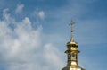 Kyiv. The golden dome of an ancient church next to a large white cloud against a blue sky Royalty Free Stock Photo