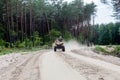 Kyiv- September 2019 Man riding a yellow quad ATV all terrain vehicle on a sandy forest. Extreme sport motion, adventure, tourist