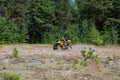 Kyiv- September 2019 Man riding a yellow quad ATV all terrain vehicle on a sandy forest. Extreme sport motion, adventure, tourist