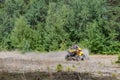 Kyiv- September 2019 Man riding a yellow quad ATV all terrain vehicle on a sandy forest. Extreme sport motion, adventure, tourist