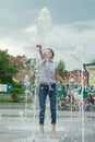 Kyiv UA, 19-07-2018. Cheerful young teen girl in city fountain, girl in wet clothes is having fun and enjoying the cool summer Royalty Free Stock Photo