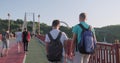 Kyiv UA, 31-07-2019. Two friends teenage boys walking and talking on foot bridge, view from the back, sunny summer day sunset