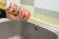 Kyiv, UA, 15-03-2019. Worker with construction syringe fills seam between the ceramic tiles on the wall and kitchen worktop with