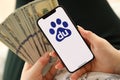 KYIV, UKRAINE - APRIL 1, 2024 Baidu icon on smartphone screen and money in female hand
