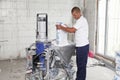 Contractor making plaster concrete with plastering machine for house plastering walls. Electric Spray Plaster Machine. Automatic Royalty Free Stock Photo