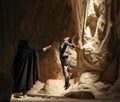 Cosplayers portray duel between characters enemies Rey Skywalker and Kylo Ren from the Star Wars universe among sandy canyon Royalty Free Stock Photo