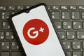 KYIV, UKRAINE - APRIL 1, 2024 Google Plus icon on smartphone screen on black keyboard