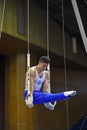 Male gymnast performing on stationary gymnastic rings Royalty Free Stock Photo