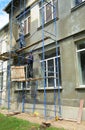 Renovating the exterior wall, the house facade the building contractors on scaffold tower Royalty Free Stock Photo