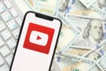 KYIV, UKRAINE - APRIL 1, 2024 Youtube icon on smartphone screen on many usd money bills Royalty Free Stock Photo