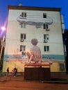 Street art mural depicts a boy sitting on the seashore, Kyiv, Ukraine