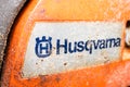 Kyiv, Ukraine - August 17, 2022: Husqvarna model 136 chainsaw body close-up logo. Old orange chainsaw