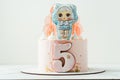 LOL Surprise character doll LOL gingerbread cookie on the top of birthday cake for a little girl on the white background