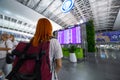 KYIV, UKRAINE - August 23, 2020: Woman, girl with backpack looks at the board with the schedule of flights and arrival at