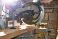 Kyiv, Ukraine - 22.07.2020: Carpenter cutting wooden board with a miter saw DeWalt, a world-famous American brand