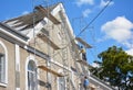 Contractors plastering house facade outdoor. Painting and plastering exterior house scaffolding wall with asbestos roof repair Royalty Free Stock Photo