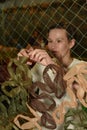 Kyiv, Ukraine - December 24, 2022: Russia's war against Ukraine. A volunteer girl weaves camouflage nets for