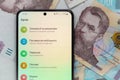 smartphone screen with mobile banking Privat24 application on 1000 Ukrainian hryvnia banknotes background