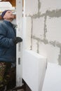 Building contractor insulating House Wall with styrofoam insulation sheets.