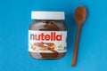 KYIV, UKRAINE - February 21: Nutella chocolate hazelnut spread in a glass jar with white cap next to wooden spoon and raw